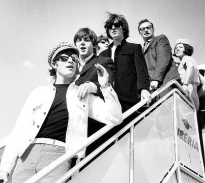 The Beatles pictured in a Black and White photo. Photo by Iberia Airlines, CC BY 2.0 , via Wikimedia Commons 