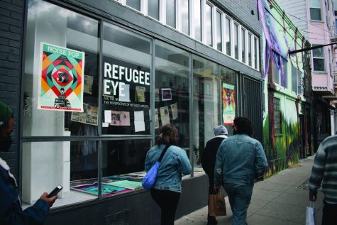 Storefront of Refugee Eye Art Gallery in San Francisco’s Mission District. Magazine clippings and art festival fills the front as the refugee art can be seen clearly from the window. (Photo by Jeremy Dukes)