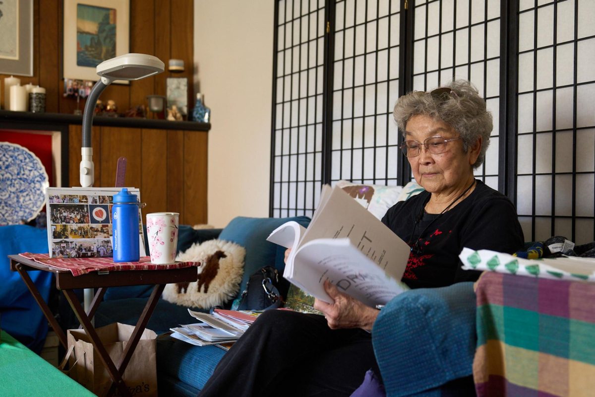 Palo Alto High School alum and activist Eimi Okano reads through documents in her Palo Alto home. Okano championed  inclusivity in California textbooks, rallied for diversity in the workplace, and raised awareness around drug abuse. 