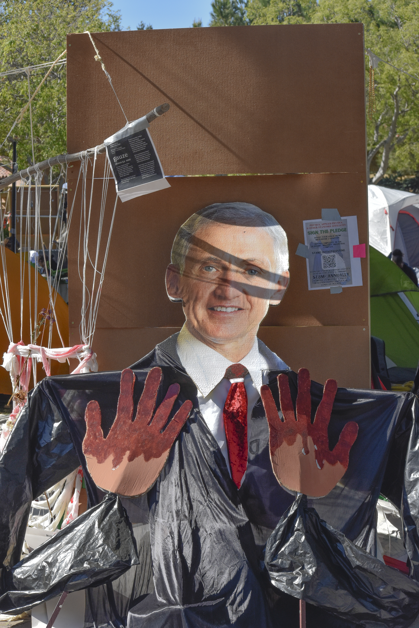 Cutout of Stanford President Richard Saller with “blood on his hands.” A visual statement made by the inhabitants of the encampments criticizes what they perceive as his role in the ongoing conflict in Gaza. It features a cutout of Richard Saller, Stanford’s president, along with a cardboard cut of hands stained with blood.