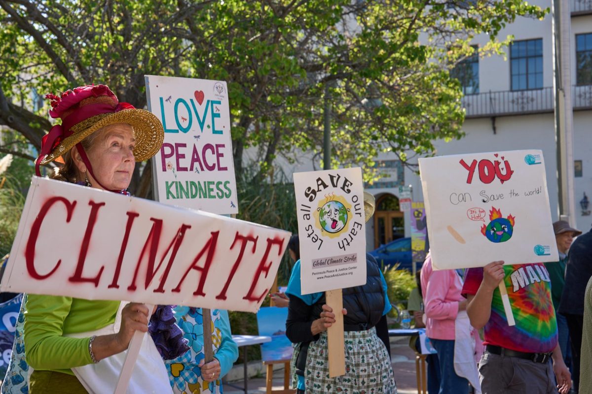  A member of the Raging Grannies holds a sign along with other protesters at the “Make Polluters Pay” protest at Palo Alto City Hall on April 18.