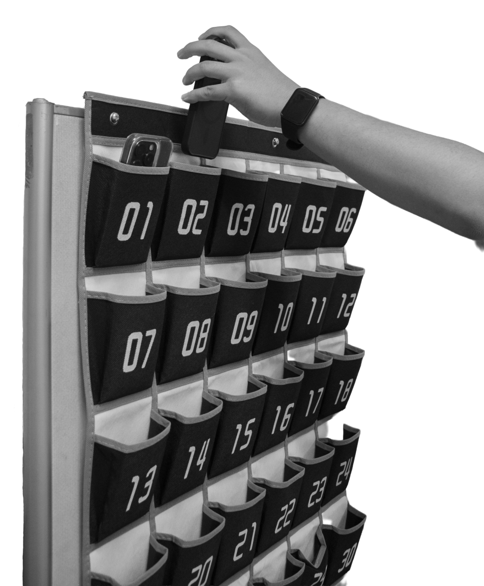 PHONES AWAY — Palo Alto High School student places a phone in a
designated cubby as required by new district policy.