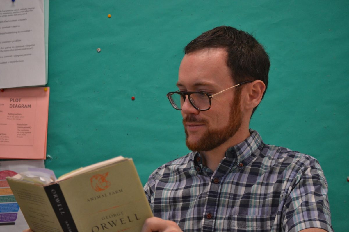 Bookworm - Joshua Knowles-Hinrichs reading in his English 10A class. Next year he will be joining the Social Justice Pathway. “One of the most rewarding parts of my job is all the things that I learned from students and all the ways that they bring in new information, connections that I might not have made myself,” Hinrichs said. Photo by Benji Sandel
