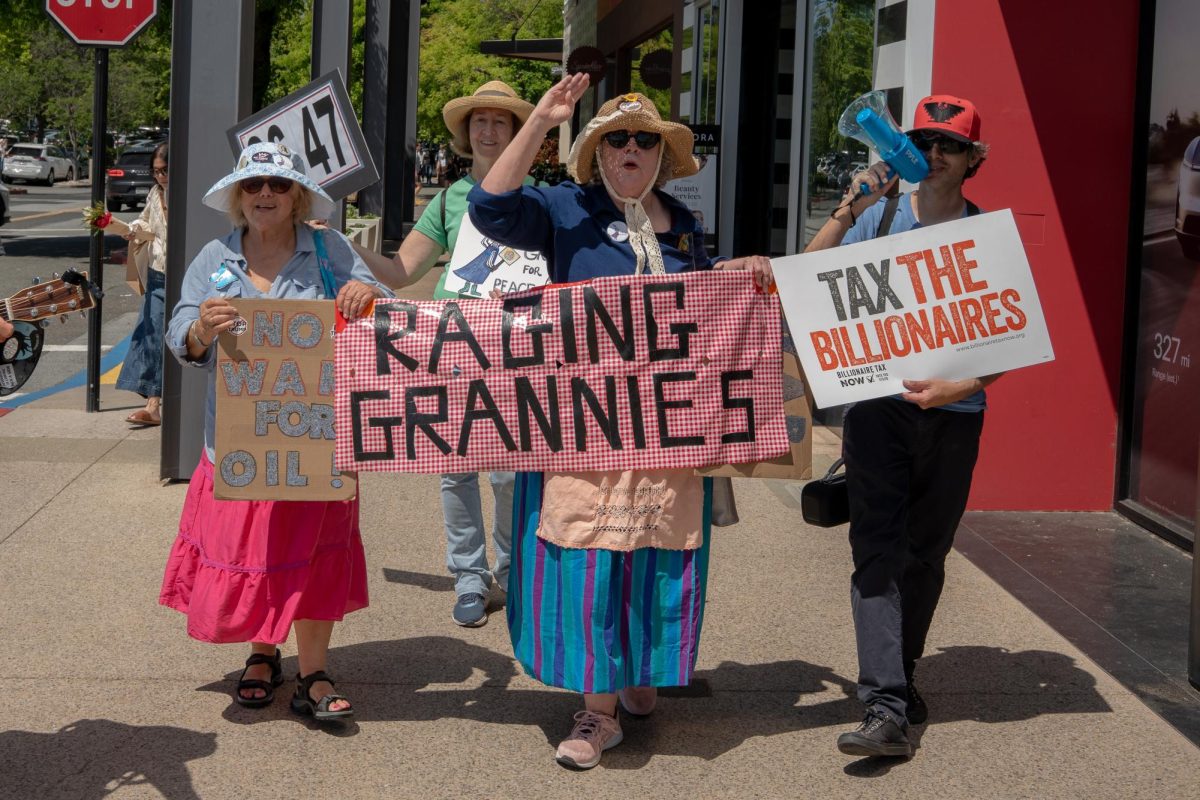 MARCHING INTO ACTION Members of the Raging Grannies assemble in front of the Tesla Store at Stanford Shopping Center. The Grannies protest and march weekly to express their opinions but Ruth Robertson, a longstanding participant in these protests, doesn’t take these opportunities for granted. “We think of ourselves as being honored to be able to present our view,” Robertson said.